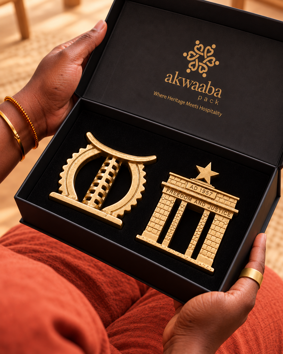 Ohene Set held in an open black gift box with brass Golden Stool and Black Star Gate